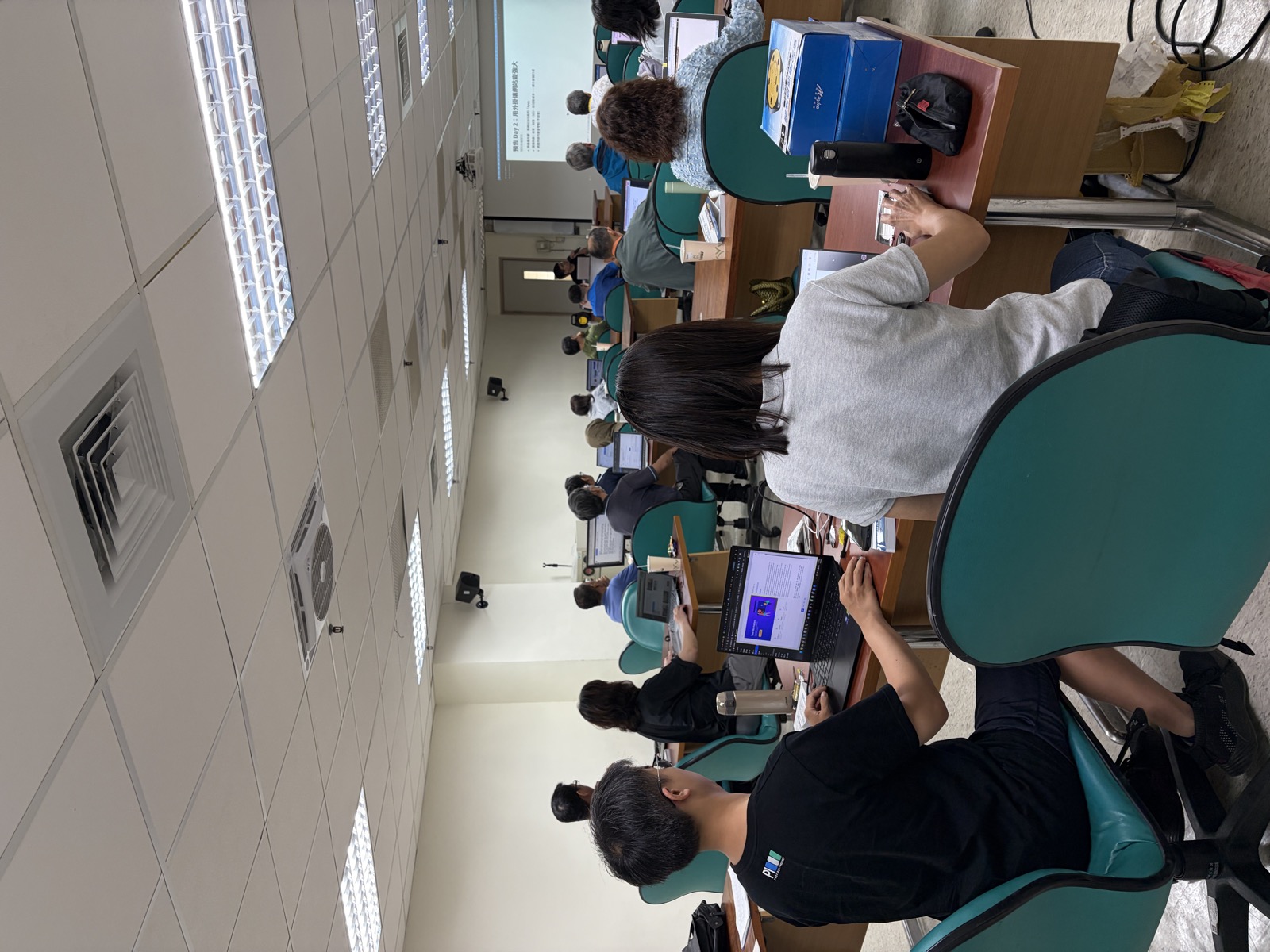 第二天的教室。投影幕上是 Day 2 的主題「用外掛讓網站更強大」,台下每個人手邊都是自己的筆電與自己的網站。